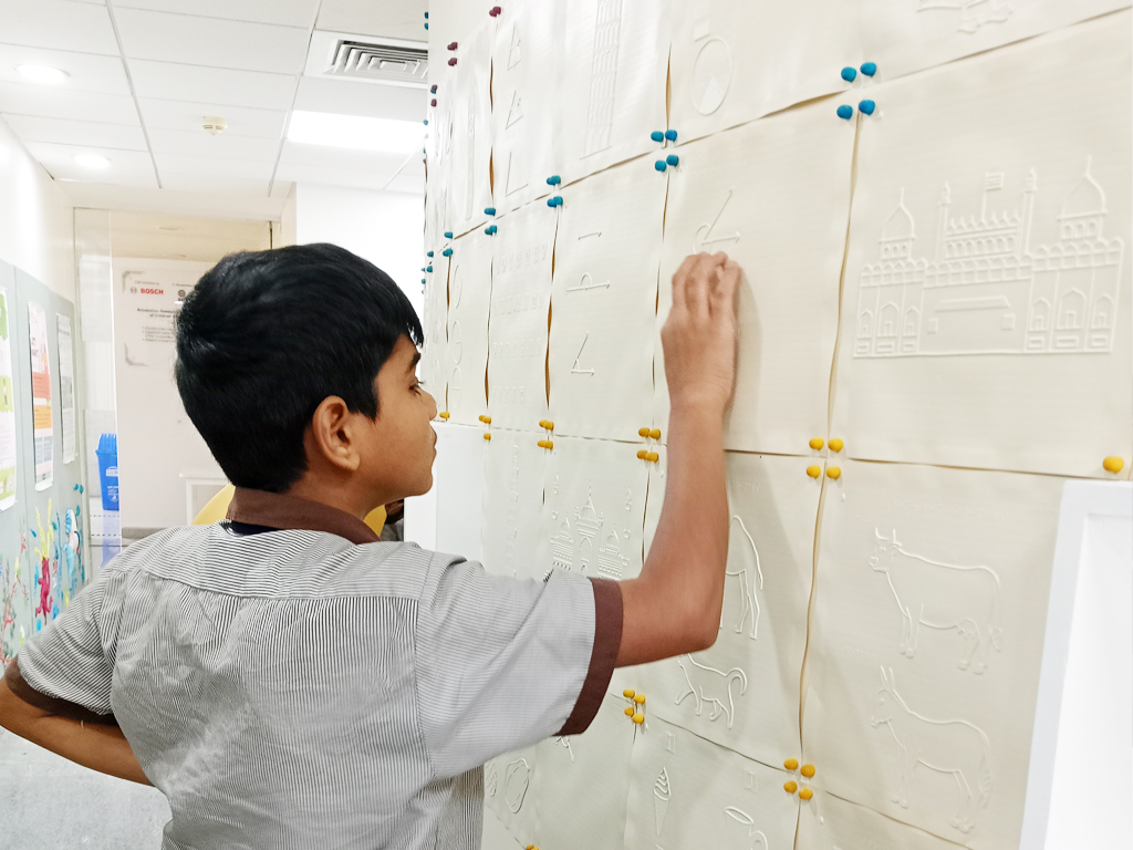 Image of a child exploring a tactile wall at ARC. Links to a video about ARC