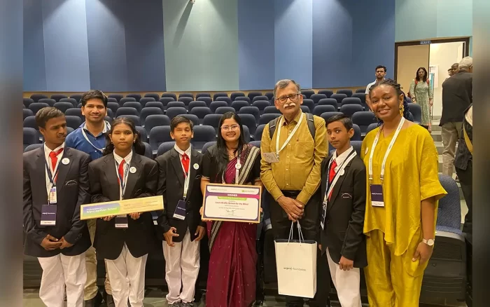 The VE team post for a photograph with Dr. Ravi Chellam holding their certificates in the Auditorium