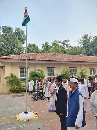 Students are participating in a flag-hoisting ceremony within the school campus.
The image shows students and staff gathered respectfully around the national flag.
It reflects patriotic spirit and inclusive participation in national observances.