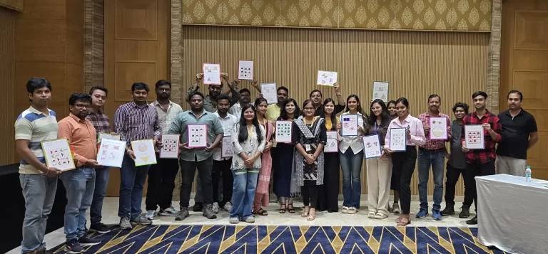 The volunteers are standing in a group together with the tactile they have made in front of them, with smiles about their contributions to VE