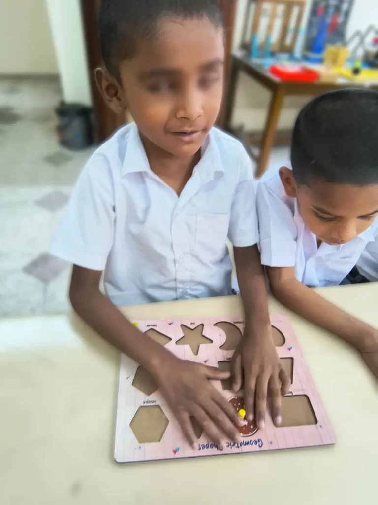 Visually impaired child is fitting shapes into its appropriate mould.