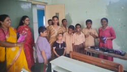 This image is of students from Devnar school for the blind, Hyderabad, Telangana, where the smiling students and teachers are seen holding Chocolates and standing for a picture, courtesy VE