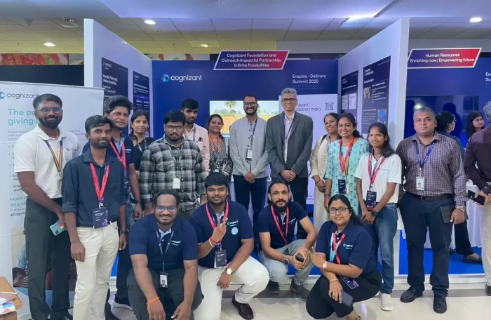 Cognizant Foundation and Cognizant Outreach stall team members standing together in front of the stall assembled for the summit