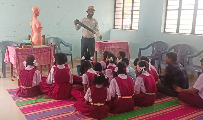 Students of the Government School for the Blind, Davanagere, attentively engage in an ARC on Wheels – Anubhav session. Guided by VE facilitator Rajesh, they explore scientific concepts through tactile torso models and hands-on demonstrations, making learning accessible and experiential.