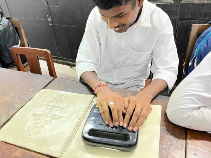 A student learning the parts of a plant through Hexis refreshable braille device