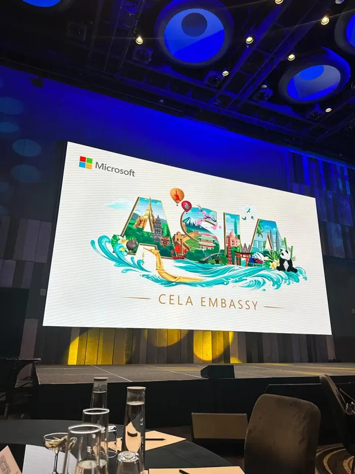 An image of the stage with a large monitor, showcasing the event's, graphic, and Microsoft logo