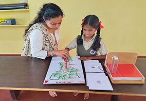 a child feeling tactile model with the help of a teacher