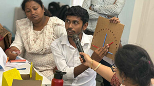 a teacher holding a Mic towards a student as he explains a learning with a board in hand