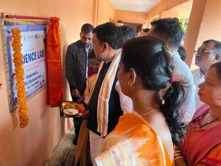 The minister is inaugurating the science lab where the team is standing with them, lighting a lamp.