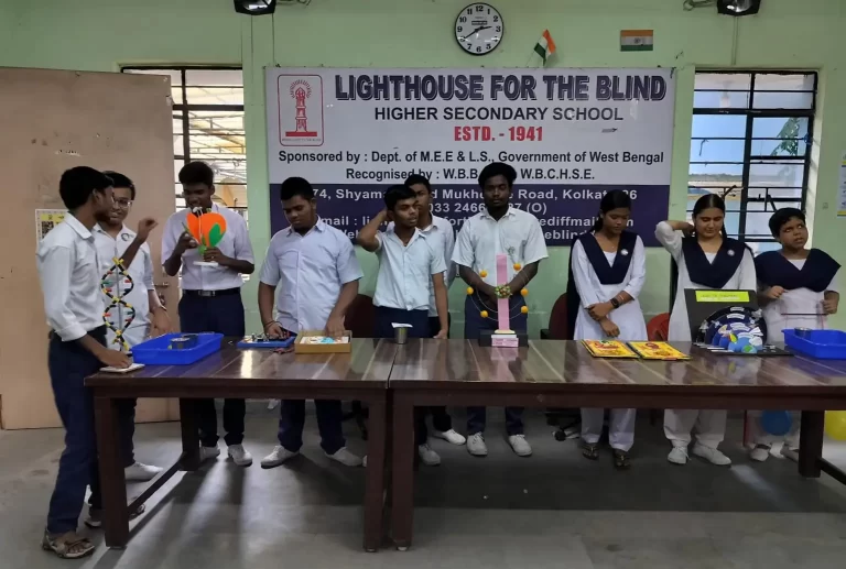 Students are standing in a line with their tactile and experiments in front of them at a table for others to view.
