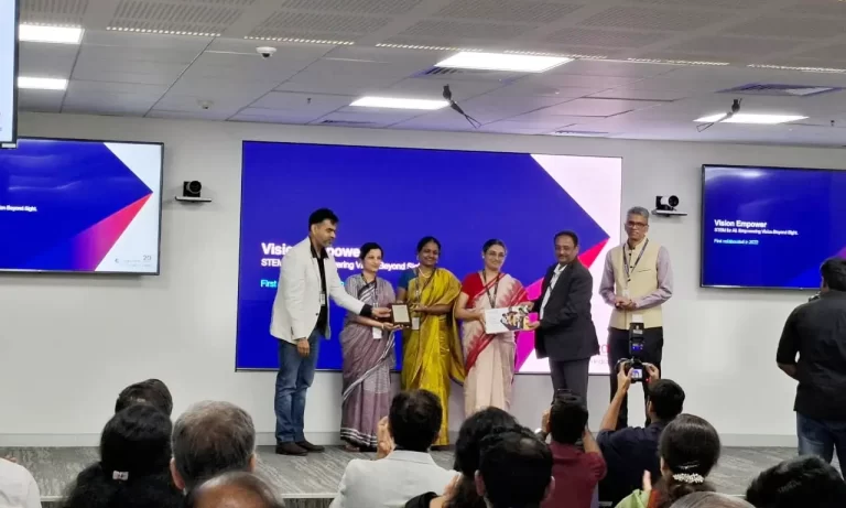 Team VE received an award from the Cognizant Foundation on stage, and all are posing, holding the trophy and certificate in their hands.