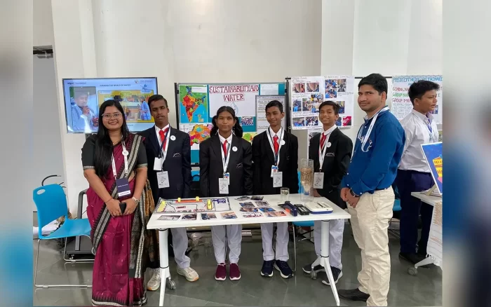 A few students and facilitators display their exhibits on a table in front of them at the Wipro Earthian Awards Exhibition